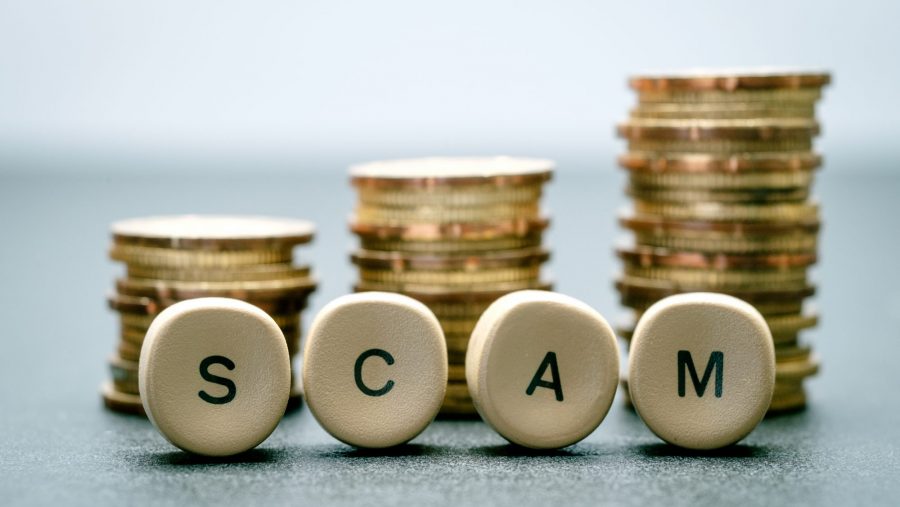 Scam scrabble letters in front of coins